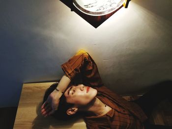 Portrait of young woman against wall at home