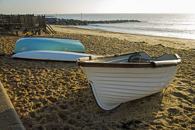 Boat moored on beach against sky