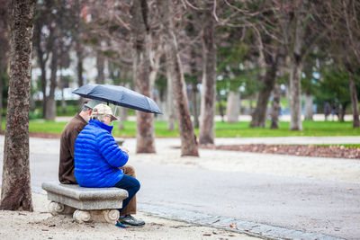 Woman sitting on bench in park