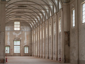 Empty white interiors without people in an old hospital building in parma, italy.