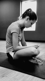 Side view of young woman sitting at home