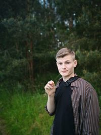 Portrait of young man standing on field