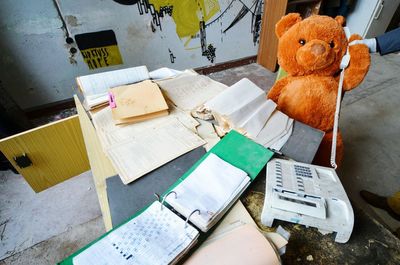 High angle view of teddy bear with documents in abandoned office