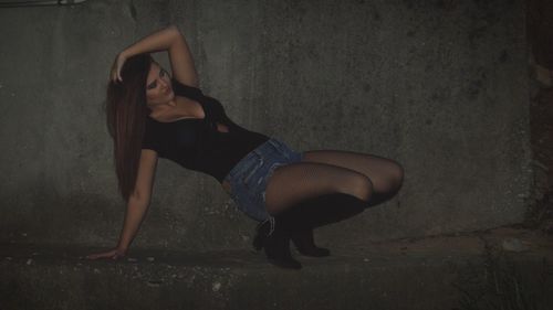 Portrait of beautiful young woman against wall