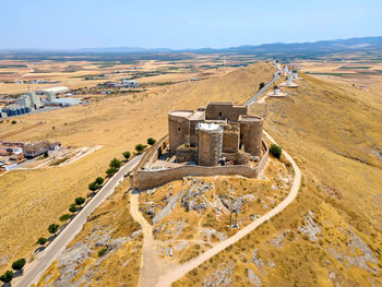 An aerial view of iconic consuegra castle and the famous windmills of la mancha, spain
