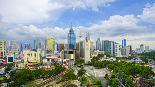 View of cityscape against cloudy sky