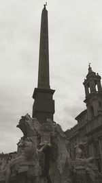 Statue in city against sky