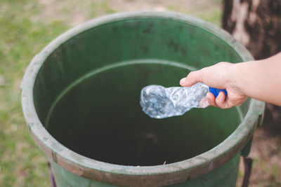 Midsection of person holding leaf in water