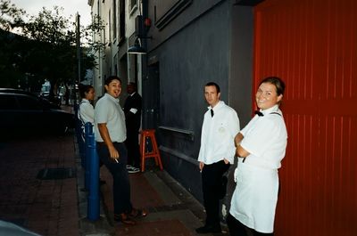 Full length portrait of friends standing in city