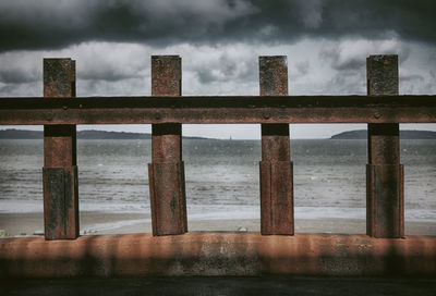 View of bridge over sea against cloudy sky