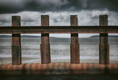 Rusty metallic fence by sea 