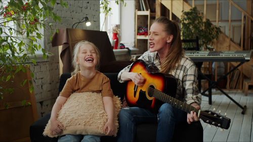 Teacher teaching guitar to girl