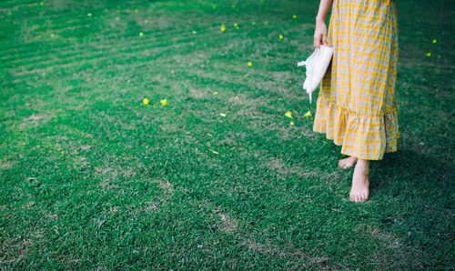 Low section of woman standing on field