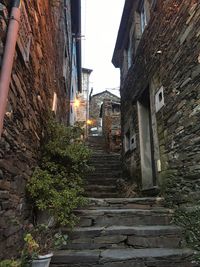 Steps amidst houses against sky