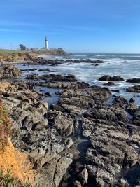 Pigeon point lighthouse from pigeon point bluffs, clear blue sky, slow shutter, on rocky coastline 