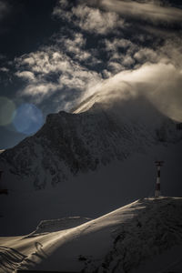 Aerial view of snowcapped mountain against cloudy sky