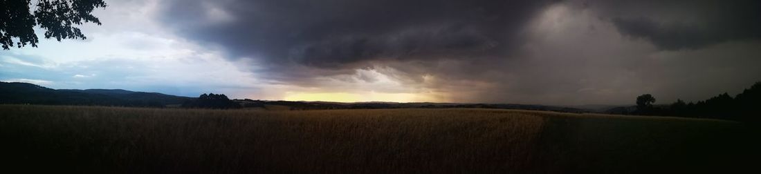 Panoramic view of agricultural field against sky