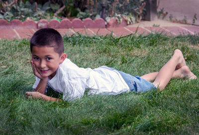 Young latino boy laying in the grass