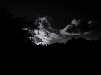 Silhouette of trees against cloudy sky