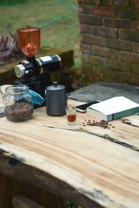 A set of manual coffee brewing tools on a wooden table and a book