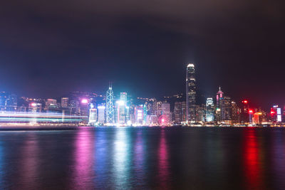 Illuminated buildings in city against sky at night