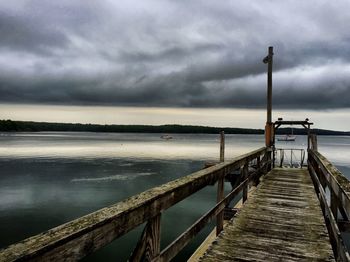 Pier on sea against cloudy sky