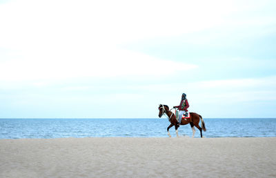 Men riding horse on beach