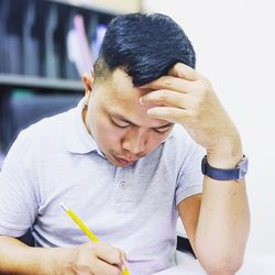 Mid adult man writing while sitting in office