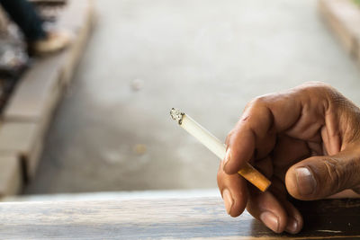 Close-up of human hand holding a cigarette