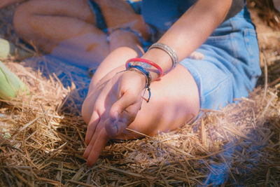 Close-up of woman hand by hay bales on field