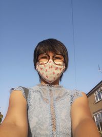 Portrait of teenage girl against clear blue sky