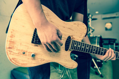 Midsection of musician playing guitar