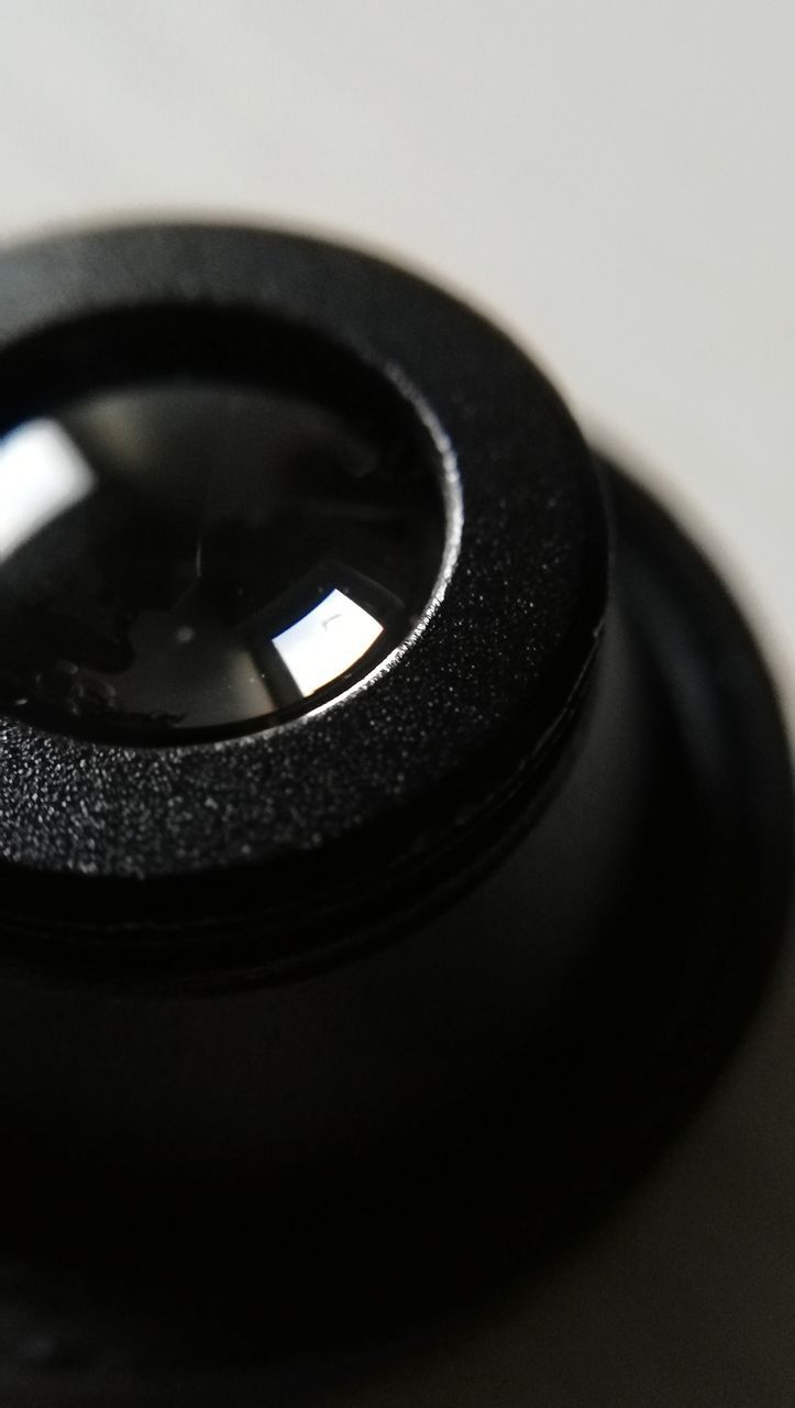 CLOSE-UP OF CAMERA LENS ON MIRROR