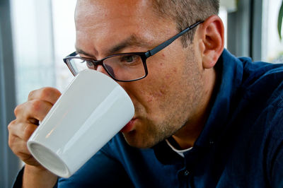 Close-up of man drinking milk from cup