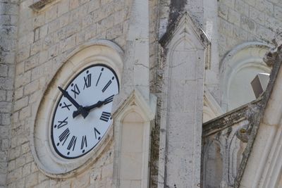 Low angle view of clock on wall