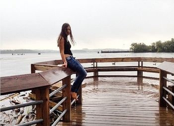 Woman sitting on wooden jetty