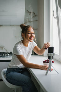 Young woman nutritionist blogger conducts a consultation or an open lesson by video link telling