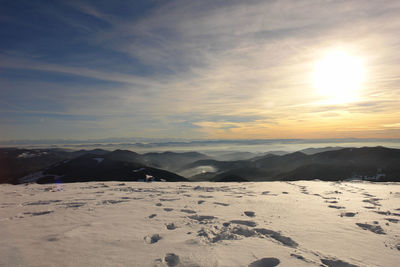 Scenic view of snowcapped mountains against sky during sunset