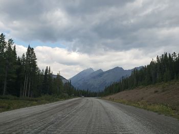 Empty road along landscape and mountains against sky