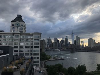 Buildings in city against cloudy sky