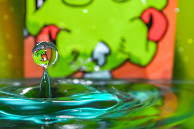 Close-up of drop falling on water