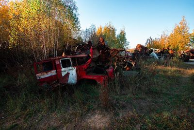 Abandoned car on field during autumn