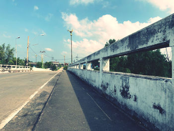 Road by bridge against sky in city