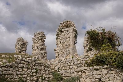 Low angle view of old building against cloudy sky