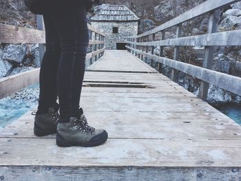 Low section of man standing on footbridge