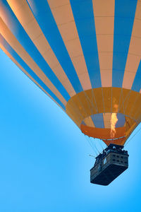 Flying hot air balloon against bright blue sky