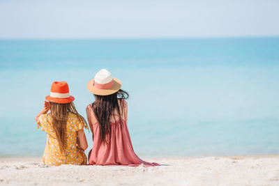 Rear view of hat on beach against sky