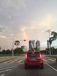 Traffic on road in city against sky