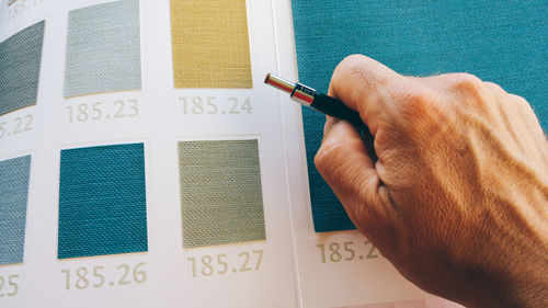 Close-up of man's hand with color swatches