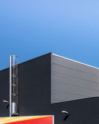 Low angle view of modern building against clear blue sky